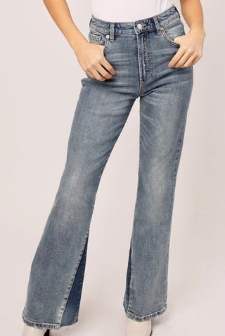 A pair of flare blue jeans with high waist and crocked design, displayed on a model without showing the upper part of the body.
