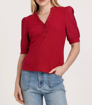 Red blouse with puff sleeves worn by a person on a white background