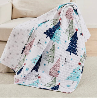 Quilt with Christmas tree pattern draped over a couch