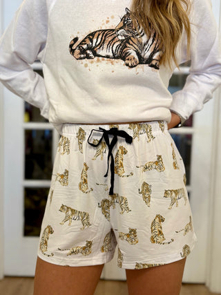 Person wearing a white sweatshirt with a tiger design and white shorts with tiger pattern.