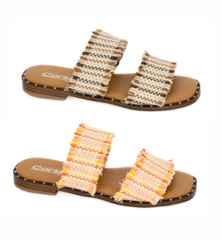 A pair of Corkys sandals, one with a frayed beige upper and the other with a multicolored frayed upper, both featuring a cushioned footbed and a durable rubber sole.