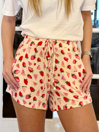 A pair of shorts with a strawberry and melon print, featuring a drawstring waist and pockets.