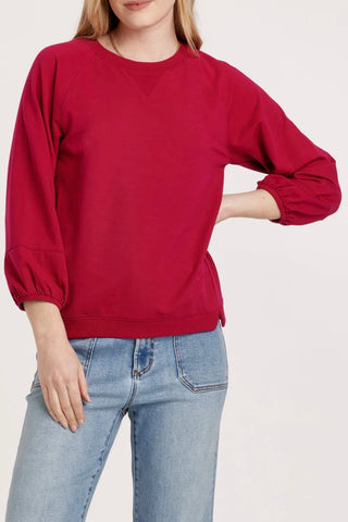 Person wearing red sweatshirt and blue jeans