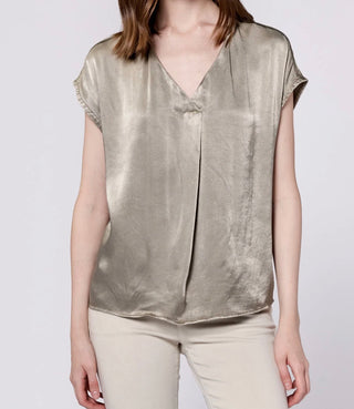 Person wearing a metallic silver blouse on a white background