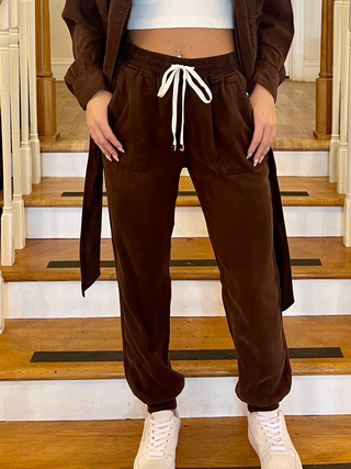 Dark oak jogger pants paired with white tennis shoes.