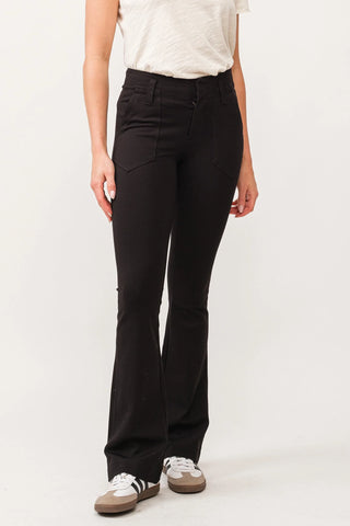 Black pants paired with white shirt and white background