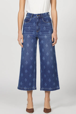 Blue patterned jeans worn by a person on a white background