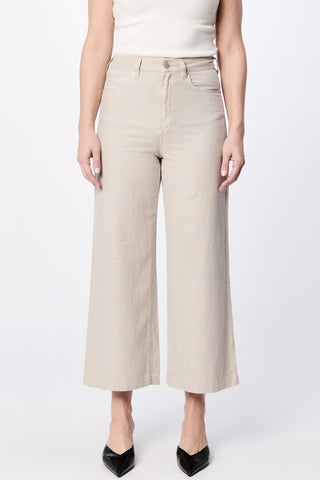 Person wearing beige wide-leg pants on a white background