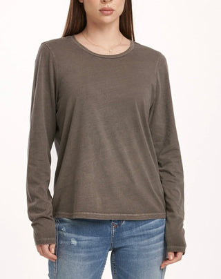 Person wearing a grey long-sleeve shirt and blue jeans on a white background