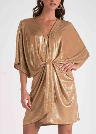 Gold shimmed dress worn by a model on a white background