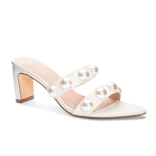 A pair of white Chinese Laundry Yarley smooth bone heels with a point toe and pearl embellishment on the straps.
