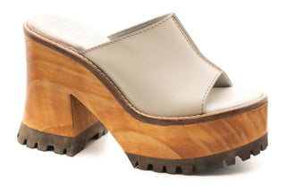 A pair of wooden block wedge with a tan upper strap.