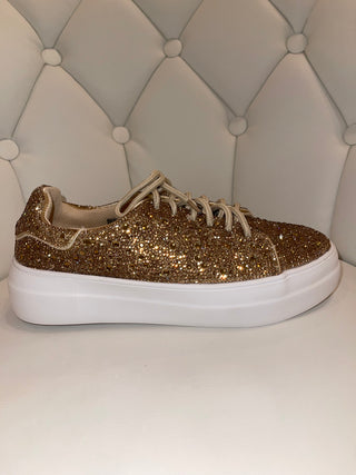 A shoe with gold rhinestones, showcasing the sparkly design on a white background.