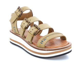 A pair of Pistachio flat sandals with buckle closure and contrast color sole.