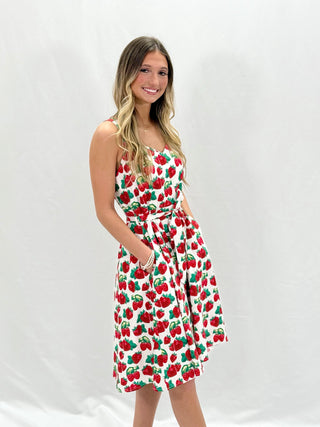 woman in a strawberry dress standing in front a white background