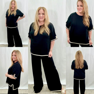 Woman wearing a black pant set with accents of off white