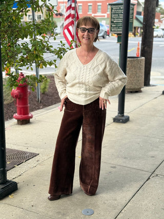 Woman wearing brown corduroyed￼ pants with cream sweater