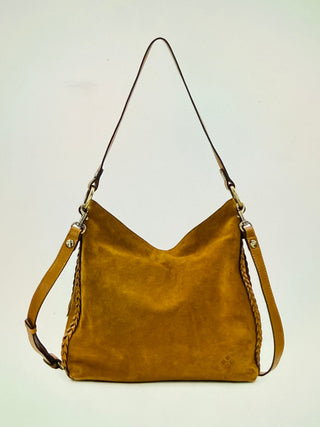 A mustard yellow suede shoulder bag with a wide strap and braided trim, shown against a plain off-white background.
