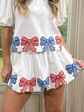 White skort with red and blue bow patterns worn by a person.