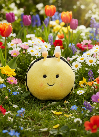 Plush bee toy in a garden with colorful flowers