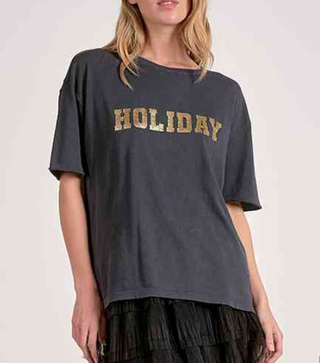 Person wearing a dark gray t-shirt with 'HOLIDAY' printed in gold on a plain background