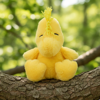 Yellow plush sitting on tree branch