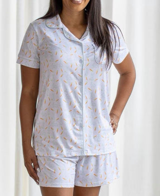 Woman wearing a white pajama set with a subtle pattern against a white background