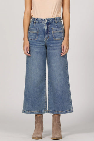 Person wearing blue wide-leg jeans on a plain background