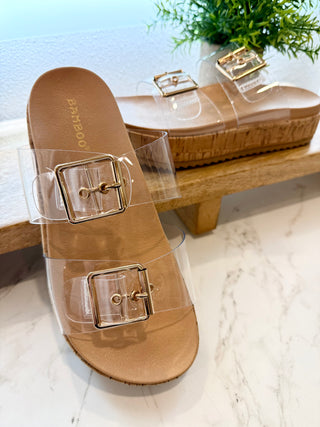 Tan sandal with clear straps on a light background