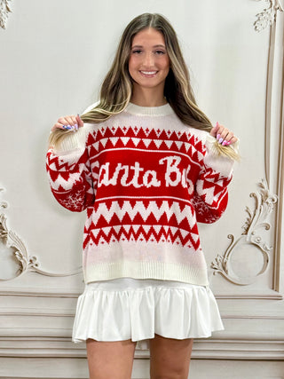 A woman wearing a festive red and white knit sweater with 'Santa Baby’