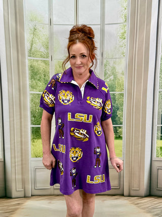 Woman wearing a purple LSU dress in a room with large windows.