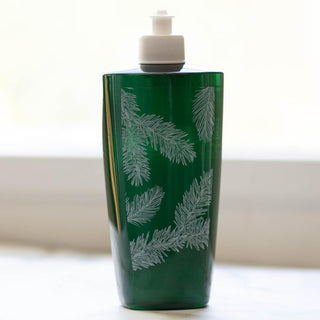 Green bottle with white leaf pattern on a light background