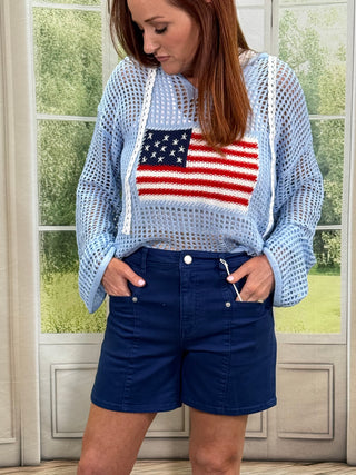Person wearing a blue shirt with an American flag design and a navy jacket.