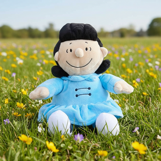 Plush toy character in a blue dress sitting on a grassy field with flowers