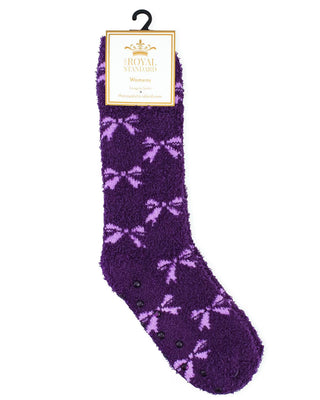Purple fuzzy socks with pink bows on a white background, featuring a brand label.