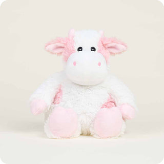 Plush cow toy with pink and white colors on a light gray background