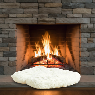 White textured weighted slippers on a stone fireplace with flames