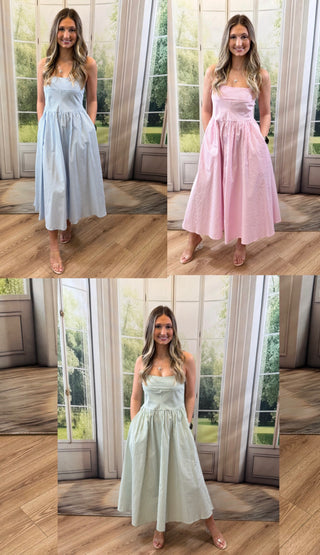 Three women wearing a pink, light blue, and green strip dress standing infringe if a window