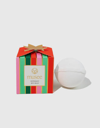 Bath balm with colorful packaging and a white bath bomb on a light gray background