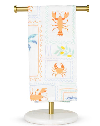 Decorative kitchen towel with lobster and crab design on a stand against a white background