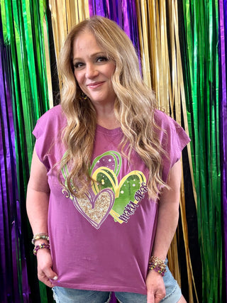 Woman wearing a purple t-shirt with a colorful heart design against a festive background.