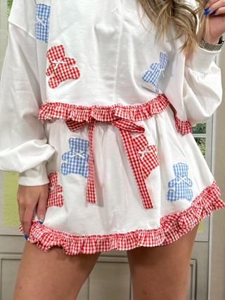 White skort with red and blue checkered accents and teddy bear patterns.