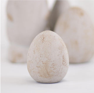 Close-up of a textured stone egg on a light background