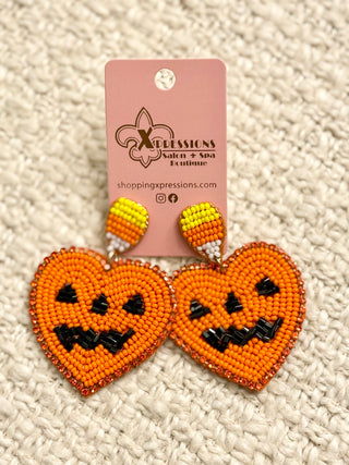 Halloween-themed beaded earrings on a textured surface with a pink card displaying 'Xpressions'.