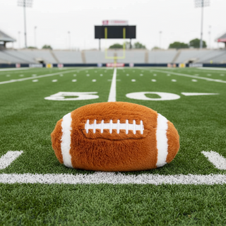 Plush football on a football field with yard lines visible