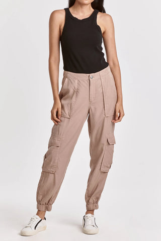 Person wearing beige cargo jogger pants and a black tank top on a white background