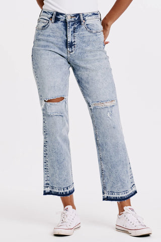 Light blue distressed jeans worn by a person on a white background