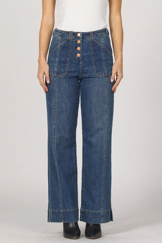 Blue jeans worn by a person on a plain background