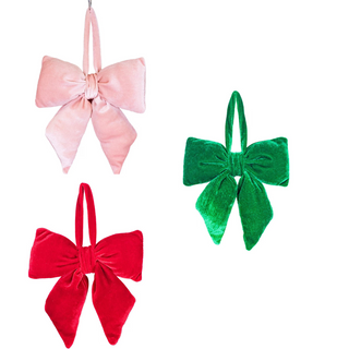 Three colorful velvet bows in pink, red, and green on a white background