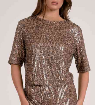 Woman wearing a sequined outfit on a plain background